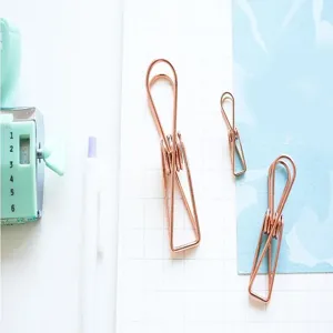 Detalle de clips de carpeta de metal oro rosa, pinza de papel papelería, organizador oficina.