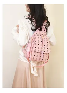 Detail view of pink leather backpack featuring cute rabbit monogram pattern and adjustable straps.