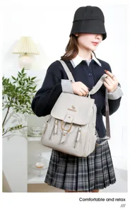 Soft leather backpack detail showing female model wearing light grey casual commuter travel bag.