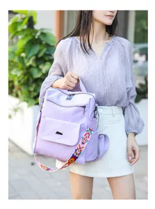 Detailed view of the light purple backpack with colorful embroidered wide strap and model.