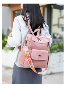 Chic pink women backpack featuring colorful wide embroidered strap, anti theft design detail.