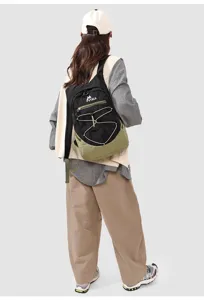 Outdoor foldable backpack featuring a black and green design with elastic cord storage system.
