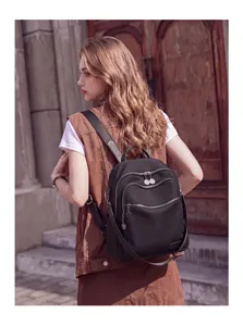 Detailed view of the stylish black women's backpack, featuring multi-pocket design for travel.