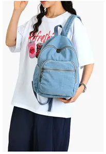 Vue rapprochée d'un sac à dos en denim bleu clair avec poche zippée et bretelles.
