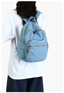 Vue détaillée du sac à dos en denim bleu avec bretelles confortables et poches pratiques.