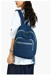Vue détaillée d'un sac à dos en denim bleu décontracté avec fermetures éclair au dos.