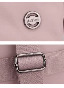 Detail shot of pink nylon backpack featuring metallic logo badge and strap adjuster buckle.