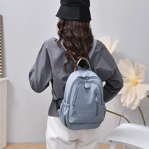 Casual light blue nylon backpack for women with multi-compartments and zip pockets.
