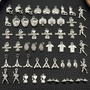 Close-up view of diverse silver sports metal charms and ball pendants for DIY jewelry making.