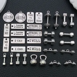 Close-up of fitness theme alloy charms featuring dumbbells, kettlebells and motivational text.