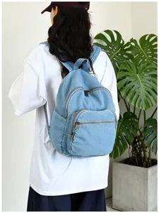 Sac à dos en denim bleu vue détaillée montrant les poches zippées et le design.