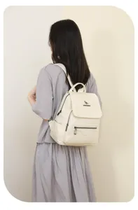 Detailed view of women's casual leather backpack on model, showing texture and design.