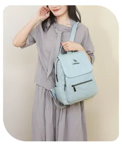 Detail view of the casual women's backpack in light blue, featuring front zipper pockets and top handle.
