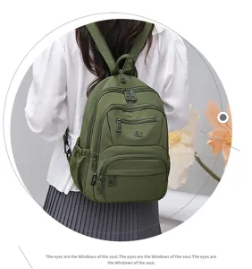 Detail view of the green nylon backpack showing multi pockets and durable zipper design.