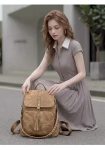 Vintage washed canvas backpack with tassel and ethnic woven strap for daily travel use.