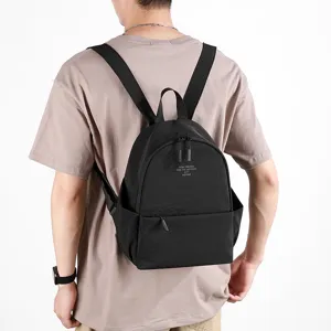 Washed nylon casual backpack in black, shown from the back on a model, minimalist daily daypack.