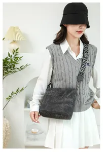 Soft leather bucket bag detail showing stylish crossbody strap and premium dark grey texture.