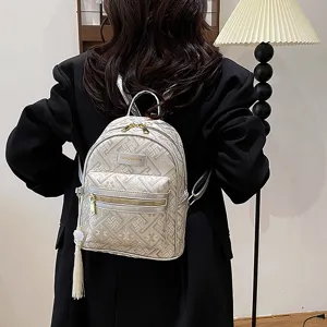 Mini backpack for women, stylish embossed nylon design with cute tassel, casual travel bag.