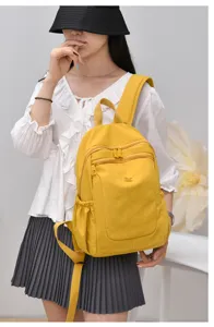 Yellow nylon backpack detail view, featuring multi-pocket design and durable shoulder straps.