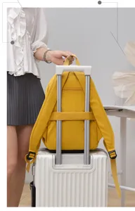 Detail view of the yellow waterproof nylon travel backpack with luggage strap and large capacity.