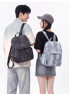 Detailed view of casual washed denim backpack featuring flap drawstring design and large capacity.