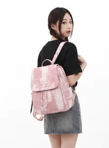 Detailed view of the stylish pink washed denim pattern backpack with drawstring and flap.