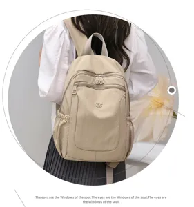 Detailed view of the casual beige nylon backpack, featuring front zipper pockets and comfortable straps.