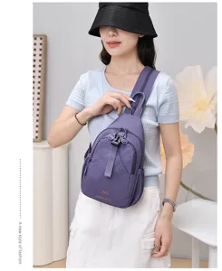 Close-up view of the purple nylon chest bag detail, multi-compartment design, worn style.