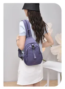 Detail view of the purple nylon sling backpack, featuring multi-compartments and adjustable straps.