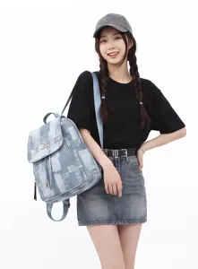 Washed denim backpack detail, casual travel daypack with drawstring flap and large capacity.