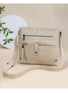Detailed view of casual beige crossbody shoulder bag with stylish tassel and front zipper pocket.