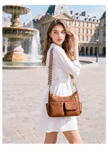 Detail view of a retro soft leather multi-pocket crossbody bag with wide striped strap.