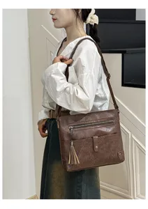 Women vintage brown leather crossbody bag with tassel and zipper pocket for daily mode.