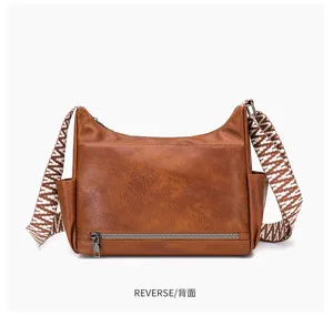 Rear view of brown retro soft leather crossbody bag showing wide strap and zippered pocket.