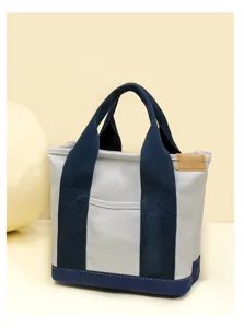 Canvas tote bag detail showing sturdy blue handles, thick grey fabric, and leather patch.
