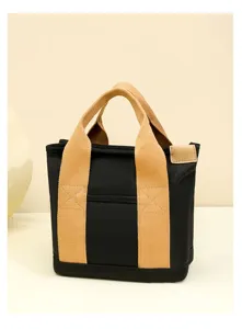 Detailed close-up of a black canvas lunch bag with beige straps and compact storage design.