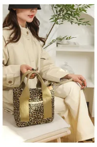 Detailed shot of a stylish leopard print canvas handbag with wide khaki handles for women.