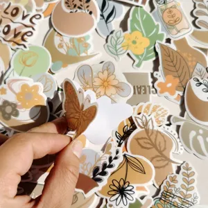 Nahaufnahme von Boho-Design Pflanzen- und Schmetterlingsaufklebern im Detail, Hand schält ab.
