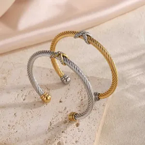 Detailaufnahme des trendigen zweifarbigen Edelstahl-Armreifs mit verdrilltem X-Muster.