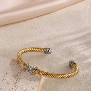 Detailaufnahme des luxuriösen goldenen Twist-Kabelarmbands mit funkelnden Kristall-Akzenten.