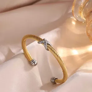 Nahaufnahme des gedrehten Kabel-Armreifs mit Kristall X-Mitte und polierten Metallkappen.