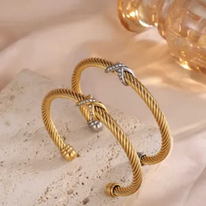 Elegantes goldenes verdrehtes Armband mit funkelndem Strass X Kreuz Design für Damen.