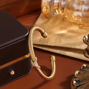 Elegantes goldfarbenes Kabel-Armband mit funkelnden Strasssteinen und Kreuz-Design.