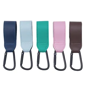 Sangles de poussette en cuir multicolore avec mousquetons noirs, vue détaillée.