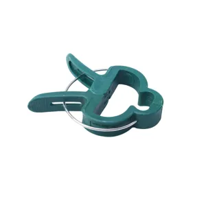 Detailed close-up of green plastic garden plant fixing clip with metal spring mechanism.
