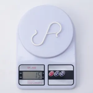 Vista detallada de gancho en S blanco, pesa 15g en báscula de cocina para colgar ollas y sartenes.