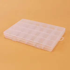 Détail de boîte de rangement en plastique transparent, montrant des compartiments clairs.