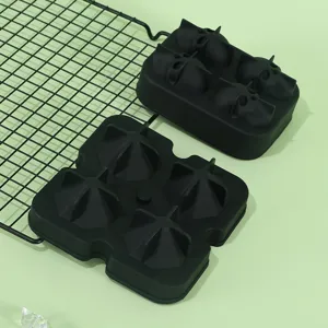 Detail view of black silicone ice tray with skull and diamond shapes for whiskey cooling.