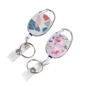 Detail view of oval retractable badge reel with floral and leaf pattern, zinc alloy carabiner.