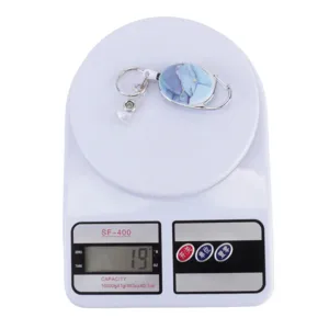 Retractable badge reel with blue marble pattern, metal key ring and clip detail.